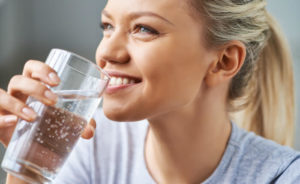 woman drinking water smiling