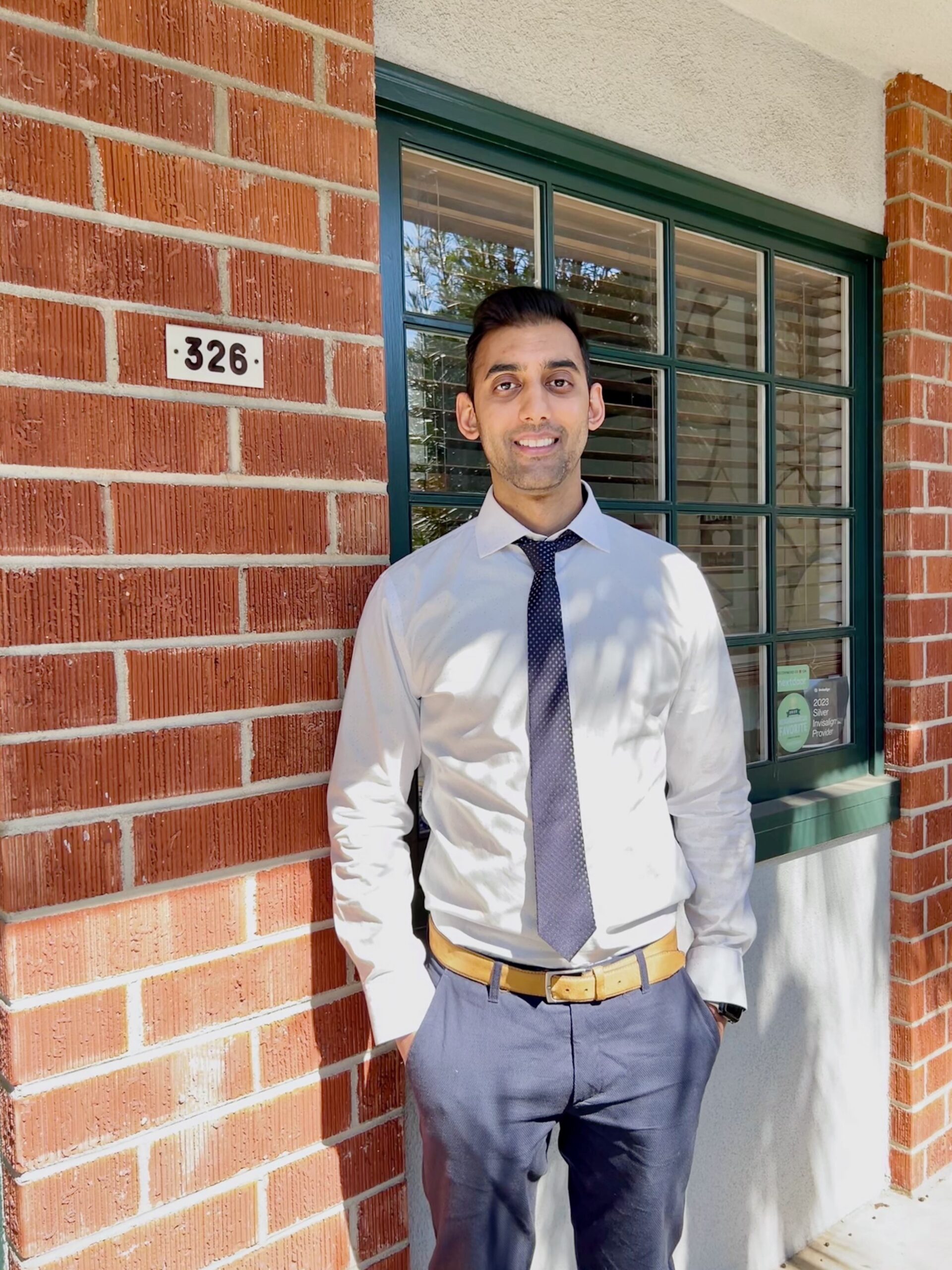 man in shirt and tie near palm tree and wall